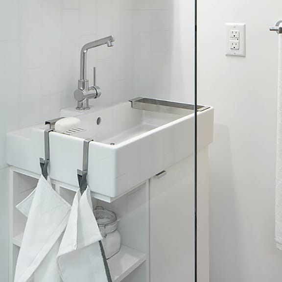 a white sink with a silver faucet and a white cabinet with a glass door.