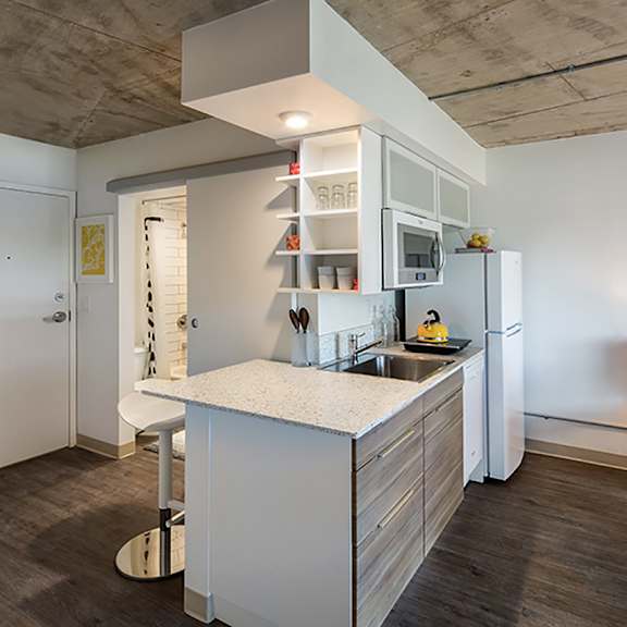 a modern kitchen with a white island and a refrigerator.