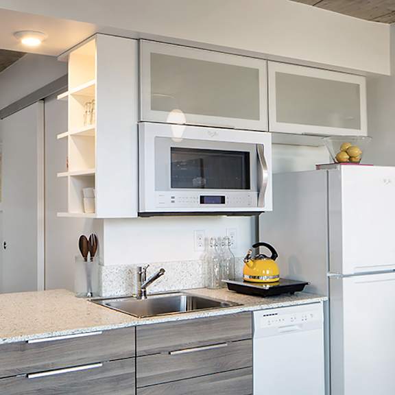a modern kitchen with a white refrigerator, microwave, and stove.