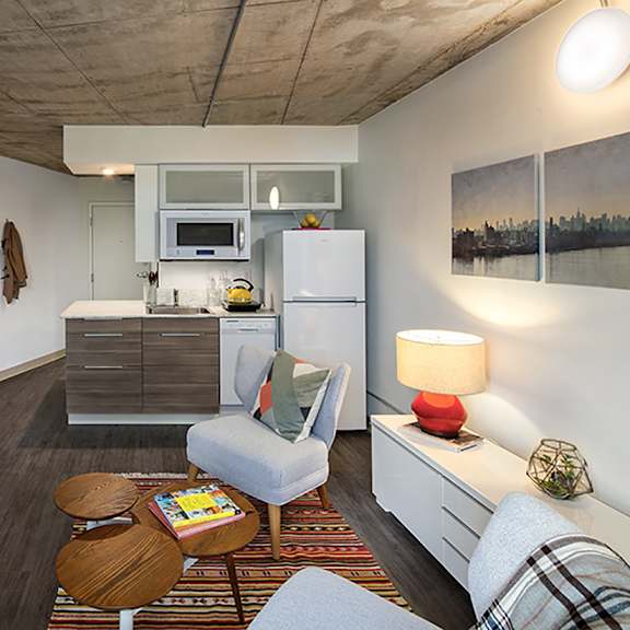 a modern kitchen with a refrigerator, microwave, and oven.