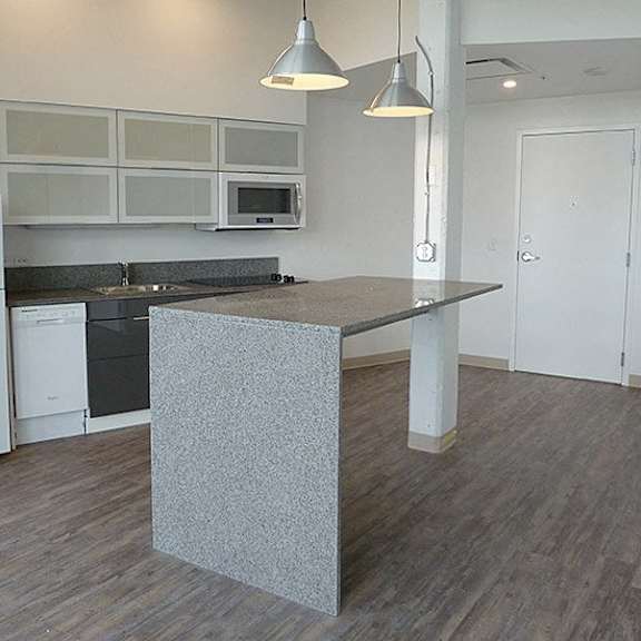 a kitchen with a white fridge and a grey island.