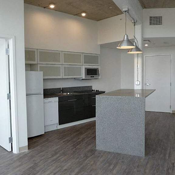a kitchen with a black countertop and white cabinets.