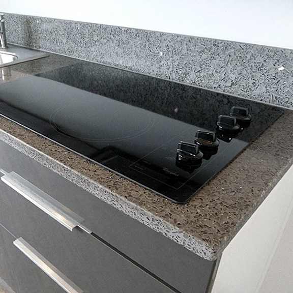 a kitchen counter with a sink and a black cutting board.