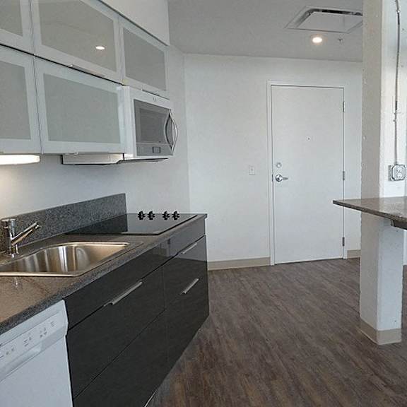 a kitchen with a sink, stove, and microwave.