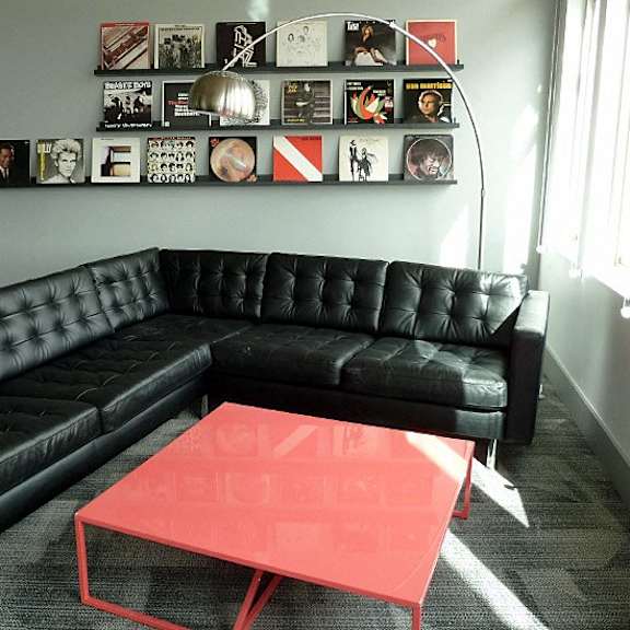 a black couch with a red coffee table in front of it.