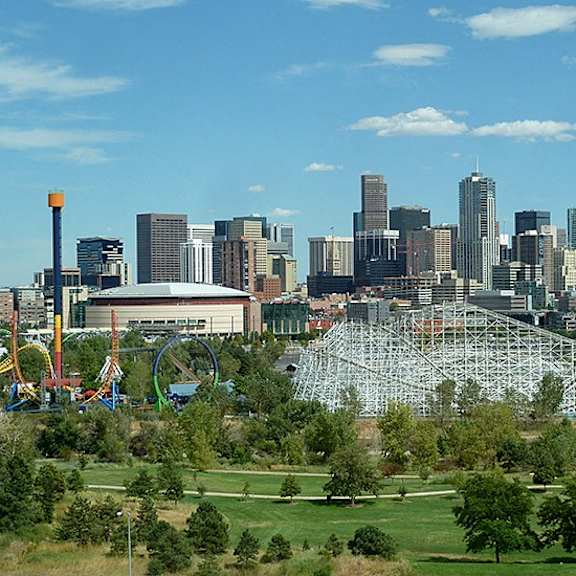 a city skyline with a large amusement park in the foreground.