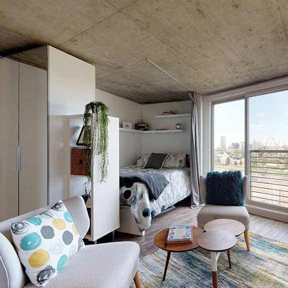a bedroom with a bed, a chair, and a table.