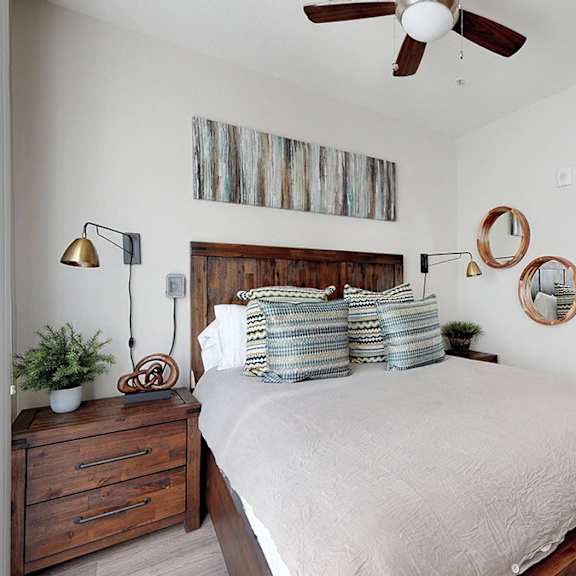 a bedroom with a bed, a chair, and a ceiling fan.