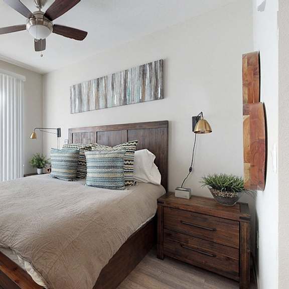 a bedroom with a bed, nightstand, and a ceiling fan.