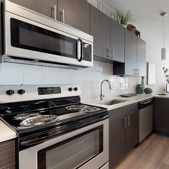 a modern kitchen with a stove, microwave, and oven.
