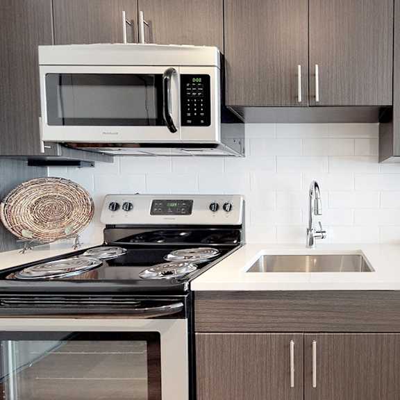 a modern kitchen with a stove, microwave, and dishwasher.