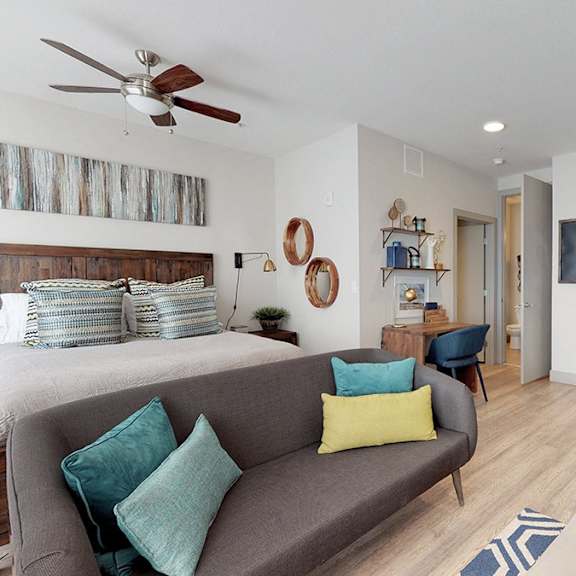 a living room with a grey couch and a brown chair.