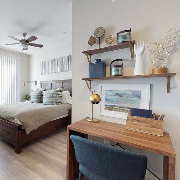 a bedroom with a bed, a chair, and a desk.