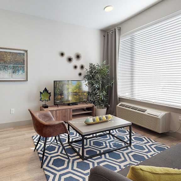 a living room with a brown leather chair and a blue and white rug.