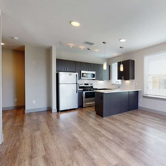 a kitchen with a refrigerator, microwave, and oven.