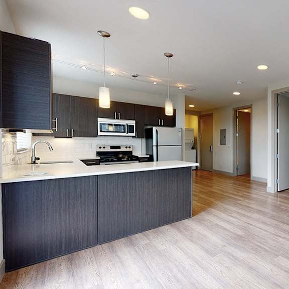a modern kitchen with dark wood cabinets and a white countertop.
