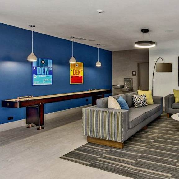 a living room with a grey sofa, a coffee table, and a blue wall.