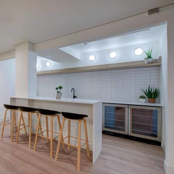 a community kitchen area with a bar and stools.