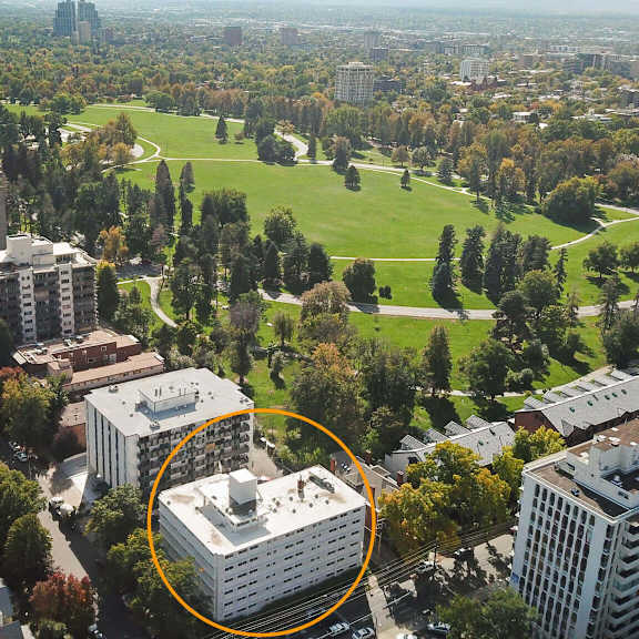 an aerial view of a city with a large white building circled in the middle.