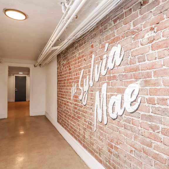 a hallway with a brick wall and a sign that says
