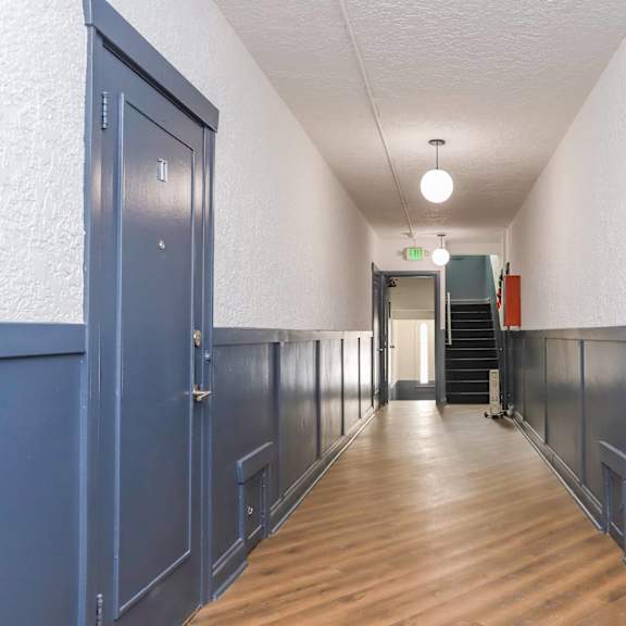 a long hallway with doors on both sides and a light on the ceiling.