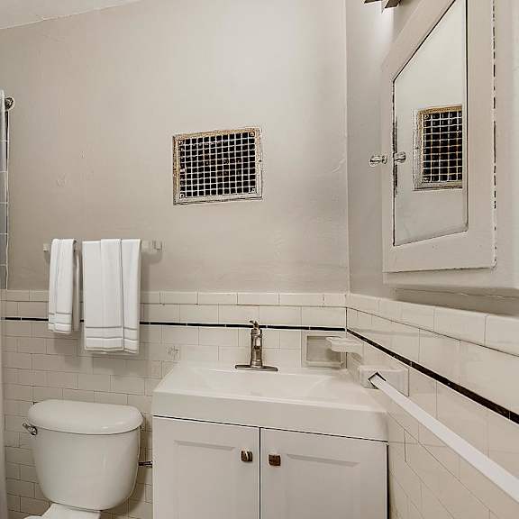 a white bathroom with a toilet, sink, and bathtub.