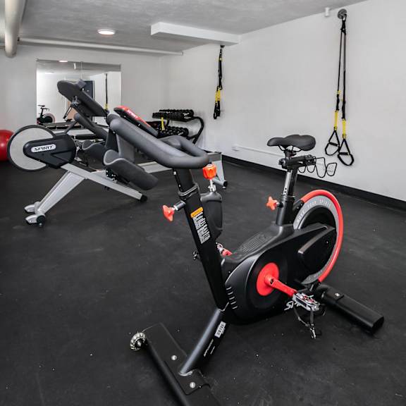 a black and red exercise bike is in a room with a black floor.