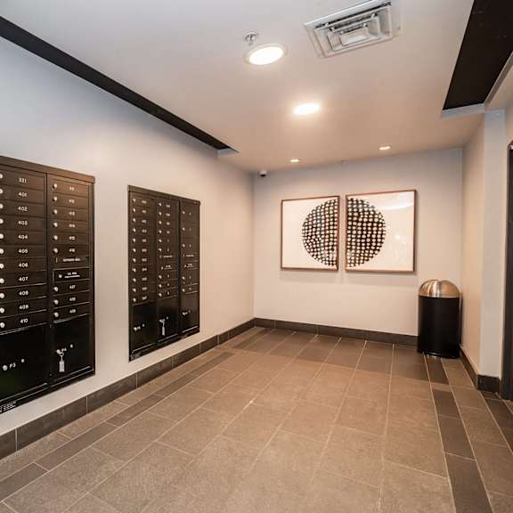 a hallway with a row of mailboxes on the wall.
