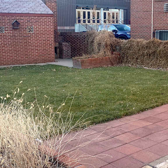 a brick building with a blue car parked in front.