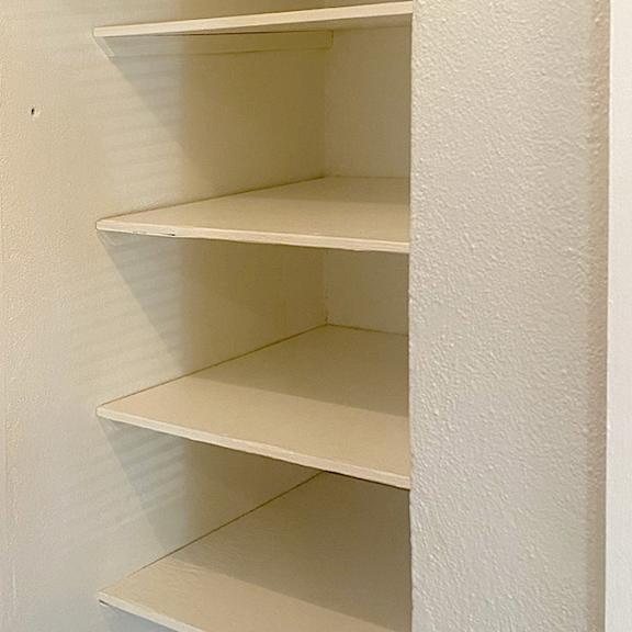 a white shelf with four shelves is shown.