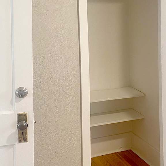 a white door with a shelf in the middle.