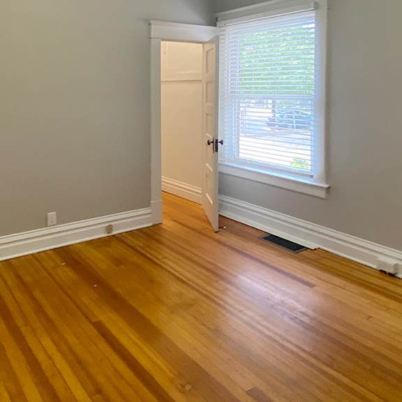 a room with wooden floors and a white door.