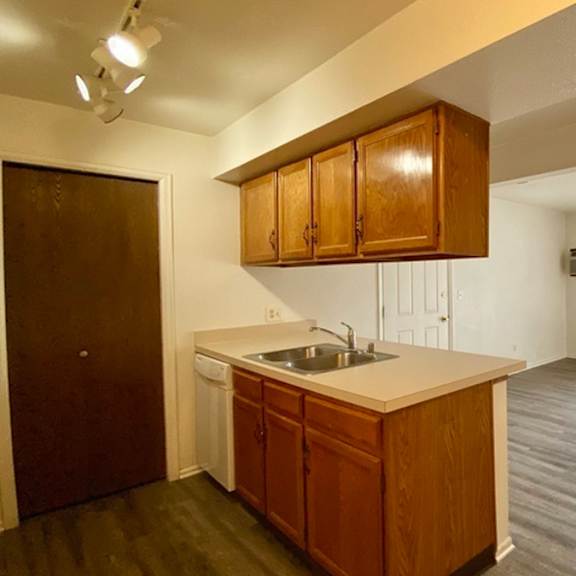 a kitchen with wooden cabinets and a white countertop.