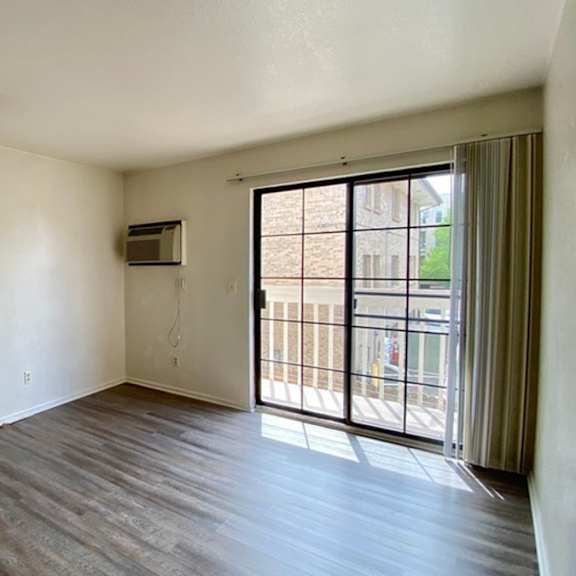 a room with a white door and a window with a view of a building outside.