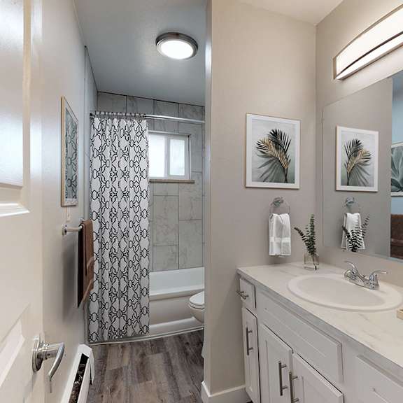 a bathroom with a white sink and a shower with a glass door.