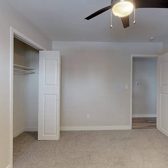 a room with a ceiling fan and two doors.