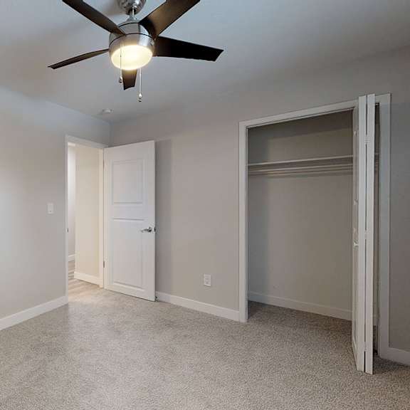 a room with a ceiling fan and a door.
