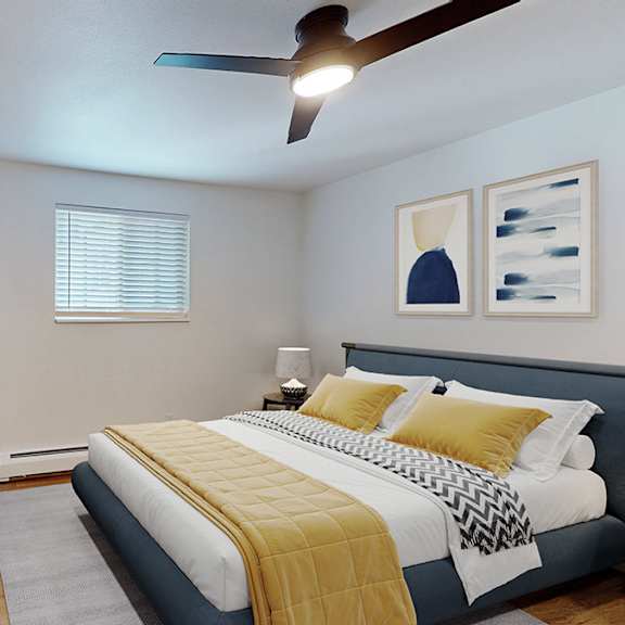 a bedroom with a queen-sized bed, a mirror, a ceiling fan, and a low set of drawers