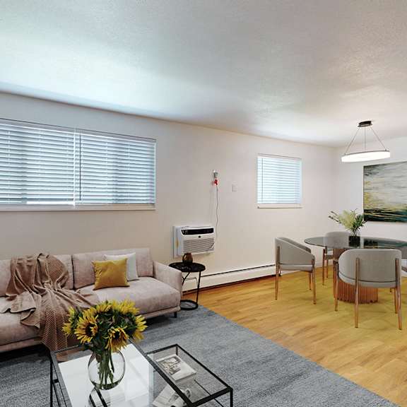 a living room with a sectional couch, a glass coffee table, and a dining table with chairs.