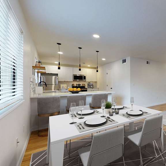 a modern dining room with a white table and grey chairs.