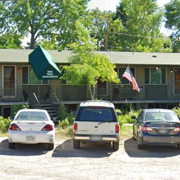 a green building with a white car parked in front.
