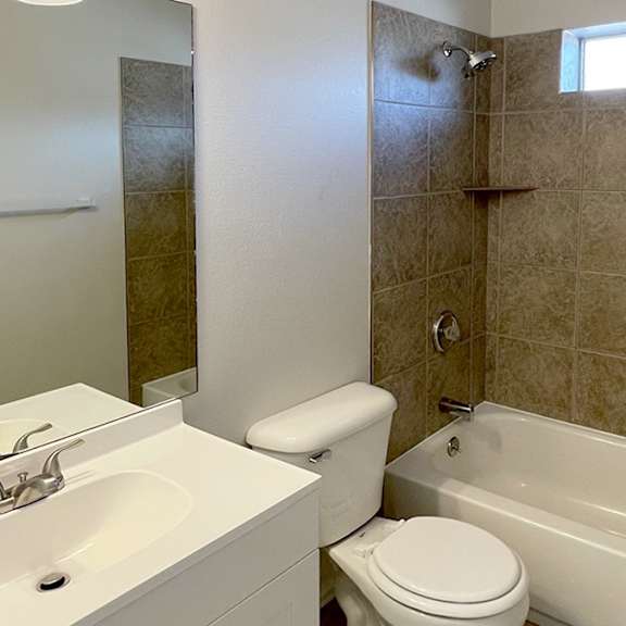 a bathroom with a white sink, toilet, and bathtub.