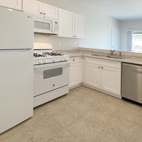 a kitchen with white appliances and cabinets.