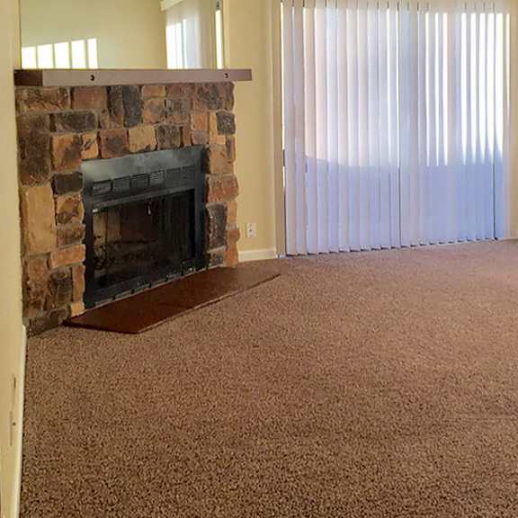 a room with a fireplace and carpeted floor.