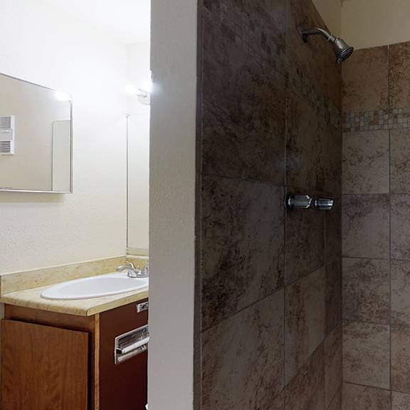 a bathroom with a marble tile shower and sink.