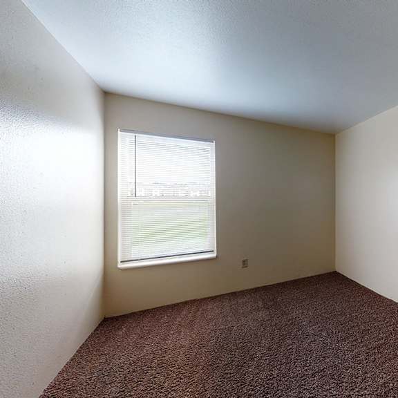 a room with a window and carpeted floor.
