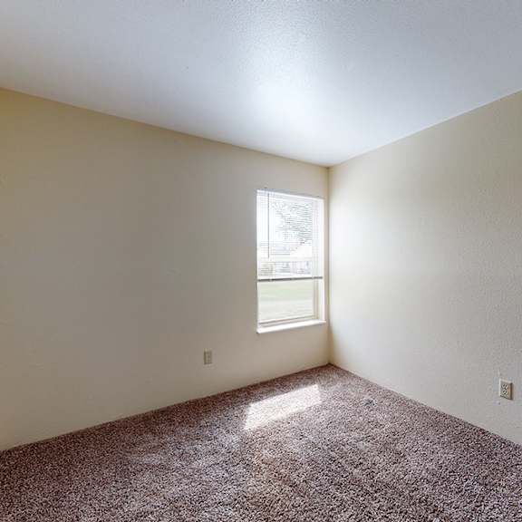 a room with a window and carpeted floor.