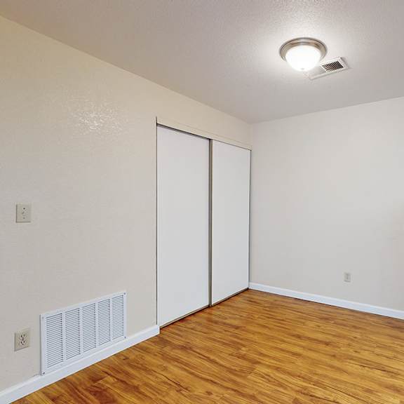 a room with a black fridge and a white wall.