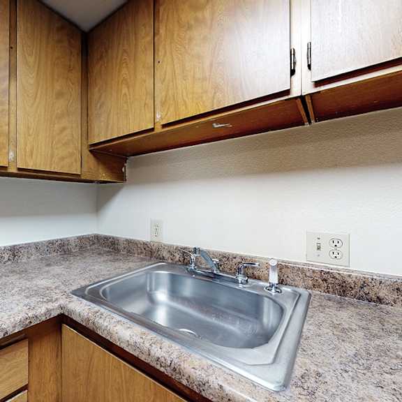 a kitchen with a granite countertop and wooden cabinets.