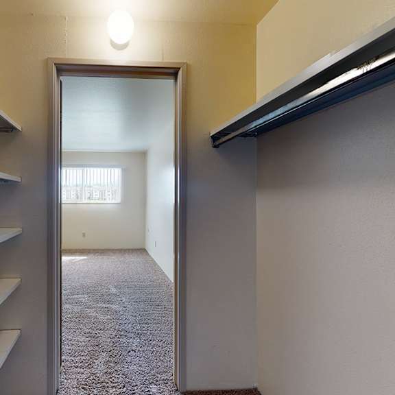a hallway with a doorway leading to a room with a carpeted floor.